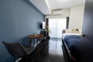 Schlafzimmer mit einem Bett, einem Tisch und Stühlen in der Unterkunft VIDA Hakata 803 - Vacation STAY 48060v in Sumiyoshi