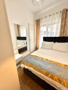 um quarto com uma cama grande e 2 espelhos em AtMangalem21, Your Cozy Apartment em Tirana