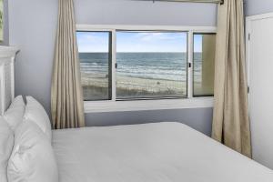 a bedroom with a bed and a view of the ocean at Pinnacle Port B3-307 in Carillon Beach