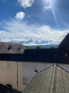 una vista del techo de un edificio con el sol en el cielo en Gite de groupe lacs du jura, en Orgelet