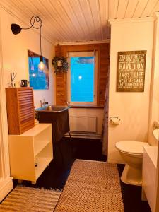 La salle de bains est pourvue d'un lavabo, de toilettes et d'une fenêtre. dans l'établissement Rustic Haven Bed and Breakfast, à Munkfors