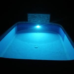 a swimming pool with a light in the dark at Arenal Surá in Fortuna