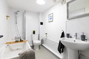 uma casa de banho branca com um lavatório e um WC em Castle Bay Apartment em Scarborough