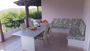 a table and chairs in a room with a balcony at Serenity Cottage House in Preveza in Flámpoura