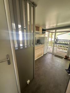 une cuisine avec une porte s'ouvrant sur une chambre avec une cuisine. dans l'établissement Camping Le Ruisseau, à Saint-André-de-Seignanx