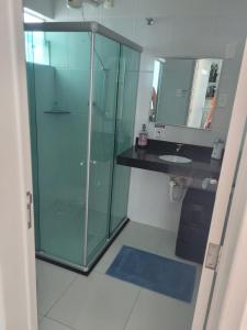 uma casa de banho com uma cabina de duche em vidro e um lavatório. em Casa para temporada - São João 2024 em Campina Grande