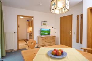 Una habitación con una mesa con un bol de fruta encima. en Gästehaus Weißenbacher-Ferienwohnungen, en Marquartstein