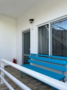 a blue bench sitting in front of a window at Vilele Bianca in 2 Mai