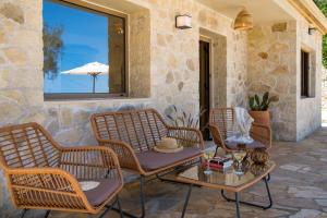 a patio with chairs and a table and a window at Villa Stamateli, Antipaxos in Antípaxos