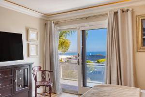 1 dormitorio con ventana grande con vistas al océano en Mermaids Cove by AvantStay Serene Backyard Ocean Views, en Topanga