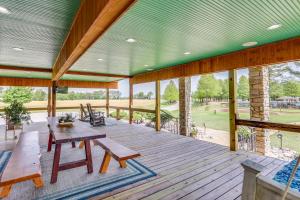 een groot terras met een houten tafel en banken bij Hornersville Vacation Rental with Private Pond! 