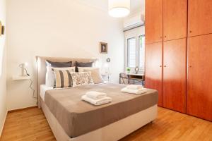 een slaapkamer met een groot bed en handdoeken bij Pangrati Gardens Apartment by Athenian Keys in Athene