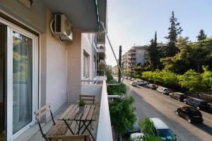 een balkon met een bank en een straat met auto's bij Pangrati Gardens Apartment by Athenian Keys in Athene