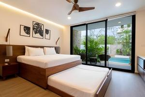 ein Schlafzimmer mit zwei Betten und einem Balkon in der Unterkunft Moots Tulum in Tulum + 287 Fotos