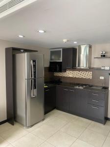 a kitchen with a stainless steel refrigerator in it at Torres Bellini I-II in Guayaquil