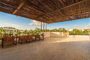 eine große Terrasse mit Stühlen und einem Holzdach in der Unterkunft Moots Tulum in Tulum