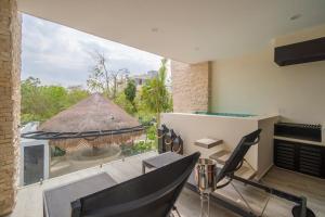 ein Wohnzimmer mit großem Fenster und Tisch und Stühlen in der Unterkunft Moots Tulum in Tulum