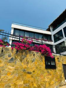 un bâtiment avec des fleurs roses sur un mur en pierre dans l'établissement Casa Vanora, à Garita