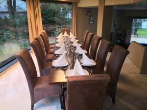 uma mesa longa num restaurante com cadeiras e mesa em Meer aan het meer em Keerbergen