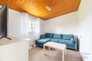 a living room with a blue couch and a table at A Casa de Carmen in Cangas de Morrazo