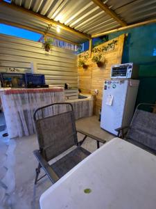 Zimmer mit einem Tisch, Stühlen und einem Kühlschrank in der Unterkunft Aloha Surf Hostel in San José del Cabo