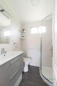 a bathroom with a toilet and a sink and a shower at A Casa de Carmen in Cangas de Morrazo +17 photos