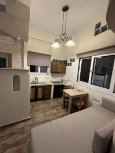 uma cozinha e sala de estar com um sofá e uma mesa em Afrodite Hotel em Tinos Town