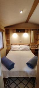 una camera da letto con un grande letto bianco con cuscini blu di MareBlue Mobilhomes & Caravans a Lido di Spina