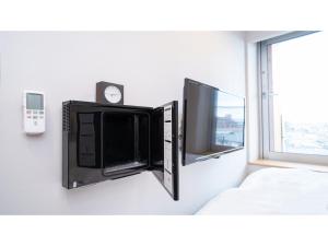 a flat screen tv sitting on a wall next to a window at Hotel Discover Nagaokakyo - Vacation STAY 34389v in Nagaokakyo +9 photos