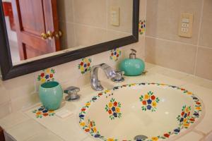 a bathroom sink with a flower painted on it at Hotel Casa Rush in Puerto Ángel +41 photos