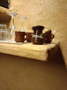 a shelf with two wine glasses and a jug and aucer at Homatino Eco Smart in Nea Moudania