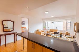 a kitchen with a counter top and a living room at Savanna Suite Rep Salvador in Quito +23 photos