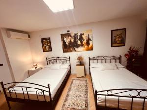 two twin beds in a room with two pictures on the wall at Iart Residence in Shirokë