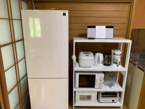 La cuisine est équipée d'un réfrigérateur blanc et d'un four micro-ondes. dans l'établissement MORIHAKU - Vacation STAY 34604v, à Kutsukake