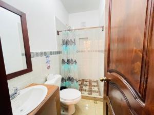 a bathroom with a toilet and a sink and a shower at Apartamentos Jasmin in San Pedro La Laguna +16 photos