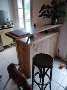een houten bureau in een kamer met een kruk en een stoel bij maison de village, a la semaine min, bord de mer in Les Sables Vignier