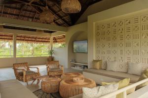 a living room with wicker chairs and tables at Schönhouse Villa Siargao in General Luna