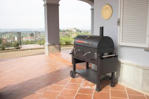 einen Grill auf einer Terrasse mit einem Fenster in der Unterkunft Villa Magna with pool Alba Hills in Govone