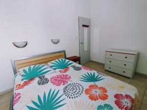ein Schlafzimmer mit einem Bett mit einer farbenfrohen Tagesdecke in der Unterkunft Le cocotier in Les Trois-Îlets