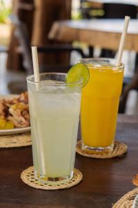 two drinks on a table with a plate of food at Paraíso Natural Ecohotel in San Bernardo del Viento