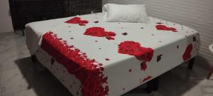 a cake with red flowers on a bed at Heinz B. in Santa Ana de los Caballeros