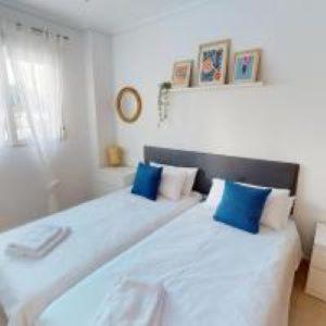 1 Schlafzimmer mit 2 Betten und blauen Kissen in der Unterkunft Casa Hanlon - Azure Property Rentals in Torre-Pacheco