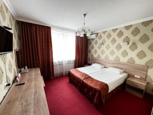 pokój hotelowy z łóżkiem i oknem w obiekcie AQ-JAIYQ w mieście Karaganda