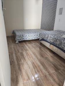 uma cama num quarto com piso em madeira em Agradavel casa familiar proxima Expo SP e metro Jabaquara em São Paulo