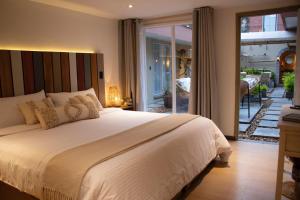 a bedroom with a large bed and a balcony at Marbore hotel & Spa in Bogotá