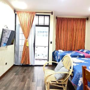 1 dormitorio con 1 cama, 1 silla y 1 ventana en Apartamento Jacob en San Pedro La Laguna