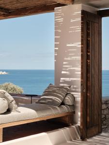 a bed in a room with a view of the ocean at Boheme Mykonos Town - Small Luxury Hotels of the World in Mikonos