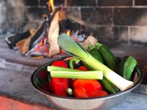 a bowl of vegetables in front of a fireplace at Mountain guest house “Fajeri” in Brestova Draga