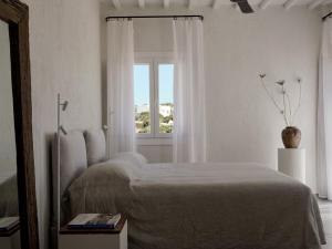 Habitación blanca con cama y ventana en Boheme Mykonos Town - Small Luxury Hotels of the World, en Mykonos ciudad