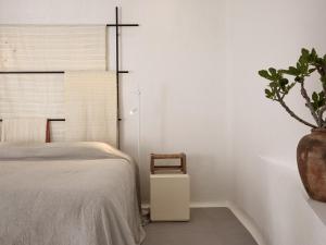 1 dormitorio con 1 cama y una maceta en Boheme Mykonos Town - Small Luxury Hotels of the World, en Mykonos ciudad